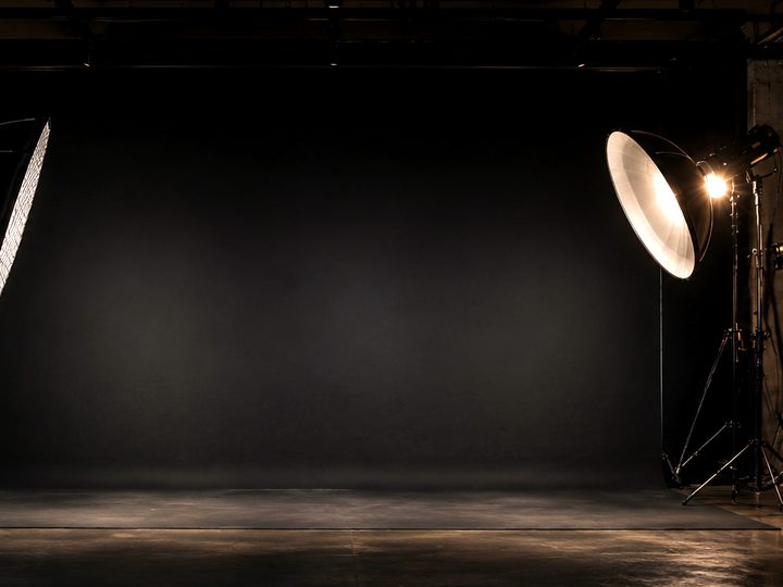Hall 2: dark loft with concrete walls, a beauty dish on a stand, an equipment cart