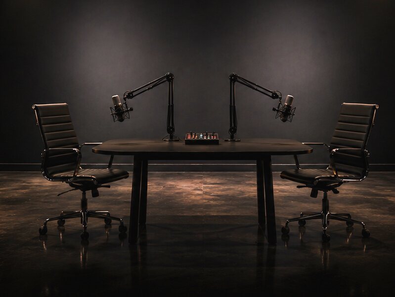 A room for two: a table with two mics on booms and two chairs